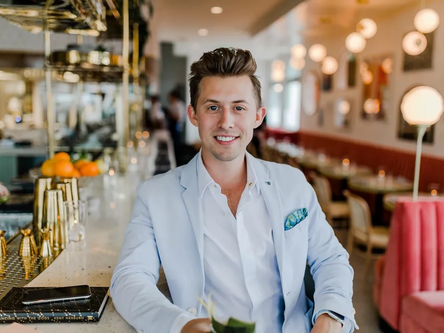 A restaurant owner stands at the bar of his dining room