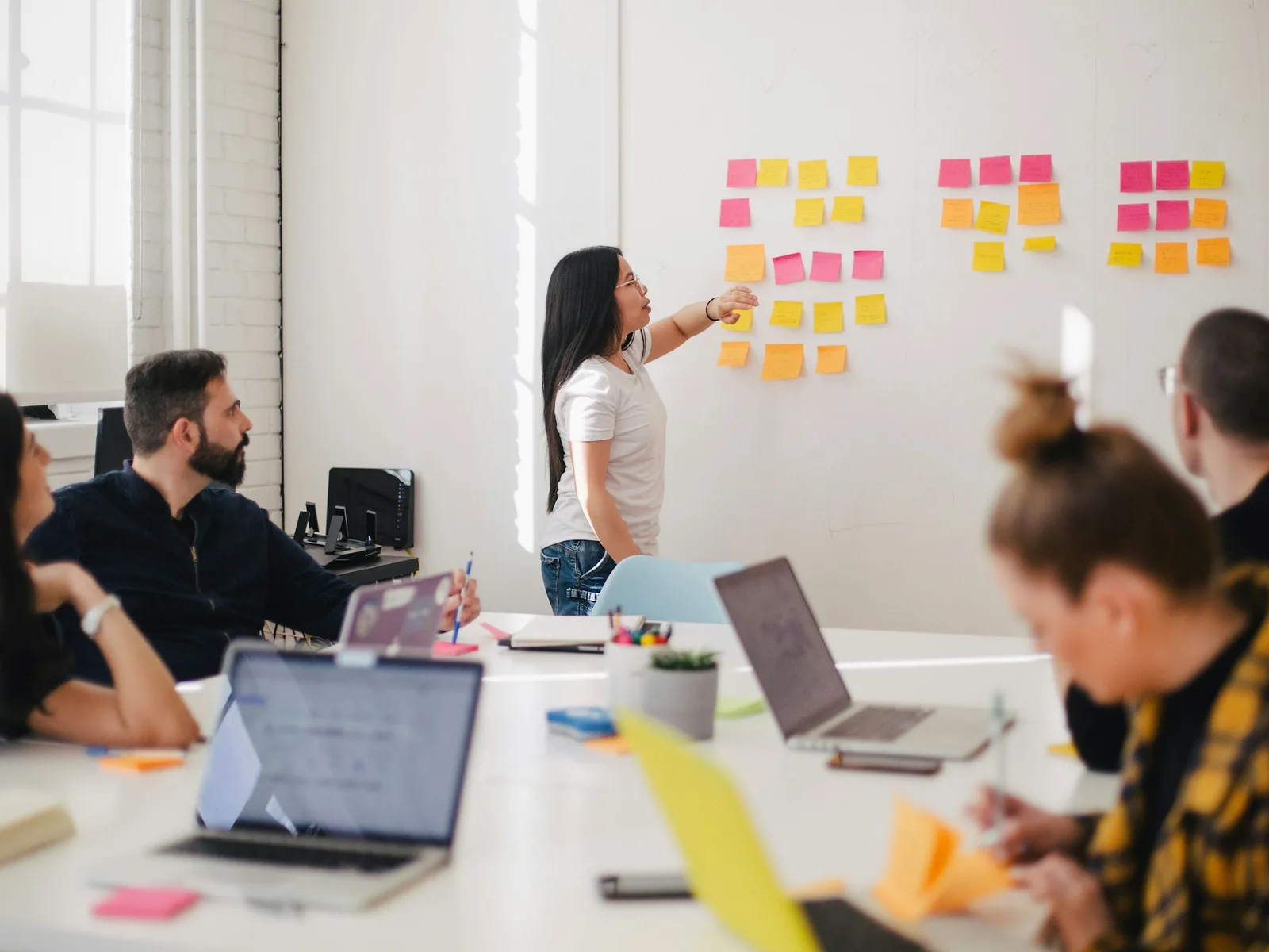 A team maps out its weekly work with sticky notes on a whiteboard
